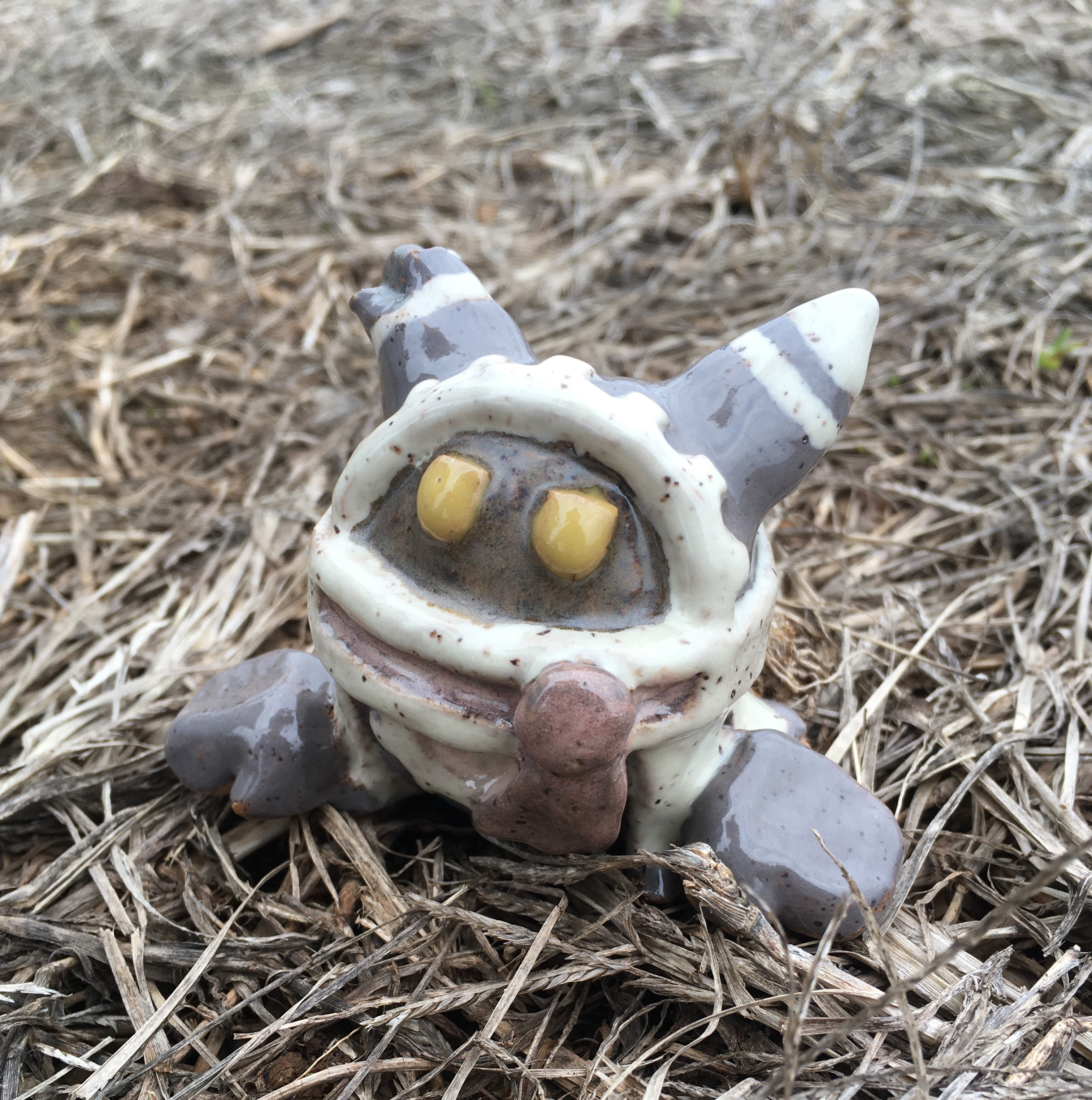 ceramic figurine of magolor in his torn-up epilogue outfit. he looks downtrodden, and his hands rest on the ground. he is surrounded by dead weeds